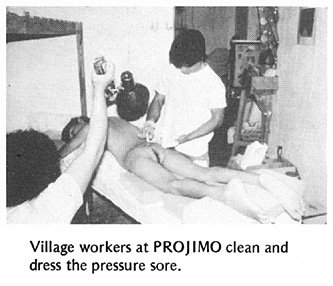 Village workers at PROJIMO clean and dress the pressure sore.