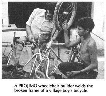 A wheelchair builder welds the broken frame of a village boy's bicycle.