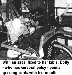 With an easel fixed to her table, Dolly - who has cerebral palsy - paints greeting cards with her mouth.