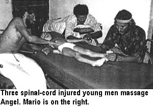 Three spinal-cord injured young men massage Angel. Mario is on the right.